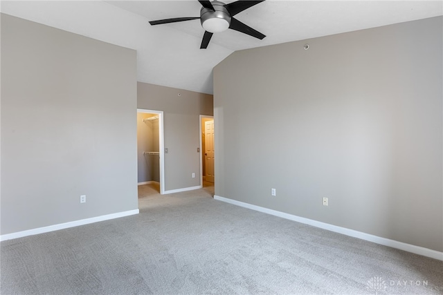 spare room featuring ceiling fan, light colored carpet, and vaulted ceiling