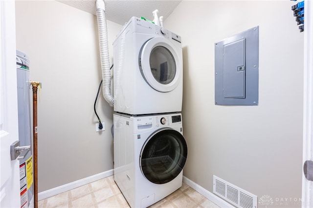 washroom with electric panel, water heater, stacked washing maching and dryer, and a textured ceiling