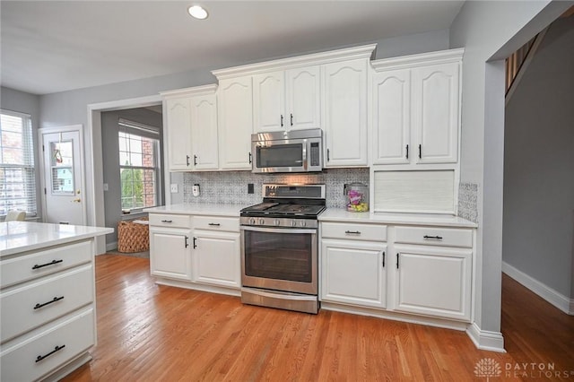 kitchen with white cabinetry, light hardwood / wood-style floors, and appliances with stainless steel finishes