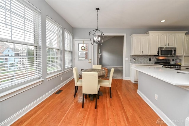 dining space featuring an inviting chandelier and light hardwood / wood-style floors