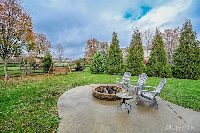 view of patio with a playground and a fire pit