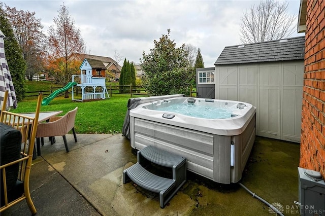 view of patio / terrace with a hot tub and a playground