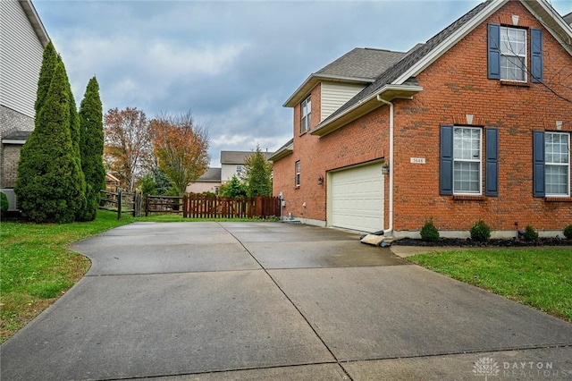 view of side of property featuring a garage and a yard