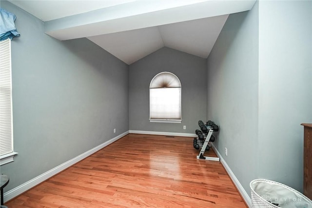 spare room featuring vaulted ceiling and light hardwood / wood-style flooring