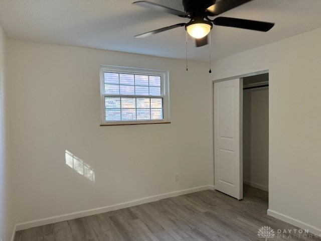 unfurnished bedroom with a closet, light hardwood / wood-style flooring, and ceiling fan