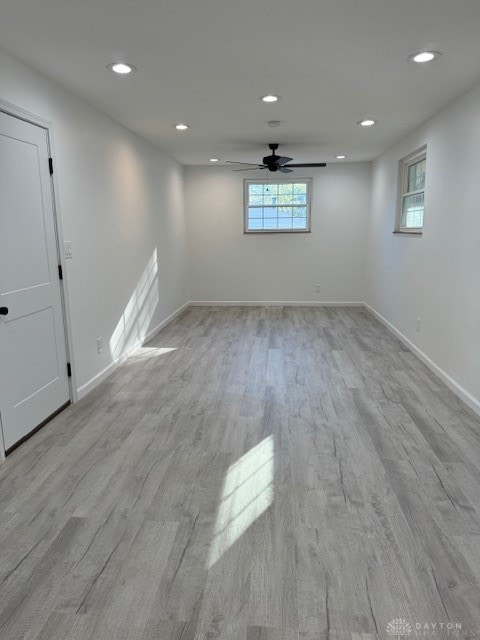 basement featuring light hardwood / wood-style flooring and ceiling fan