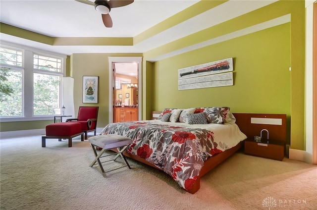 carpeted bedroom with ensuite bathroom and ceiling fan