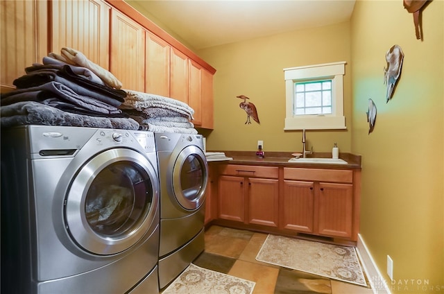 clothes washing area featuring washer and dryer, cabinets, light tile patterned floors, and sink