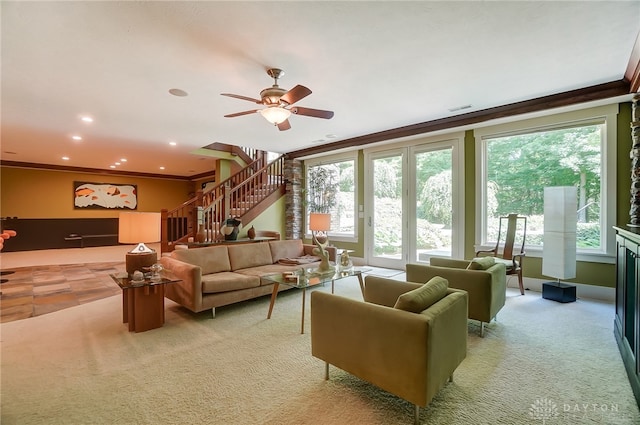 carpeted living room with ceiling fan and crown molding