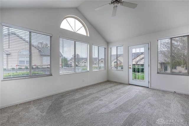 unfurnished sunroom featuring ceiling fan, plenty of natural light, and vaulted ceiling