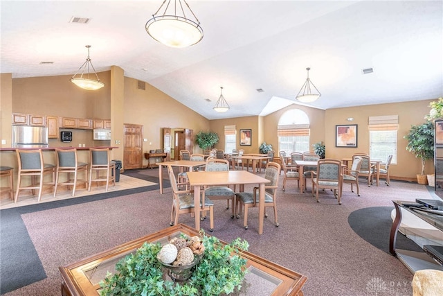 carpeted dining space featuring lofted ceiling