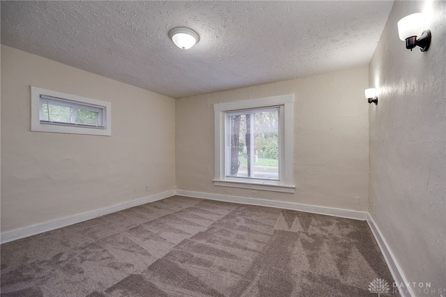 carpeted spare room with a textured ceiling