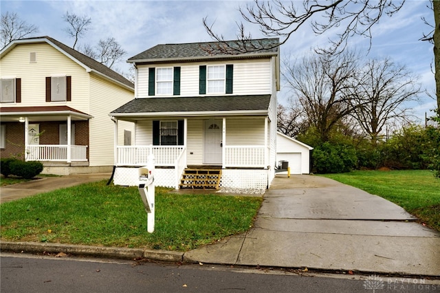 view of front of home with an outbuilding, a porch, a garage, and a front lawn