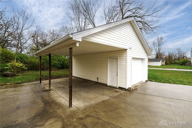 exterior space featuring a yard, a garage, and a carport