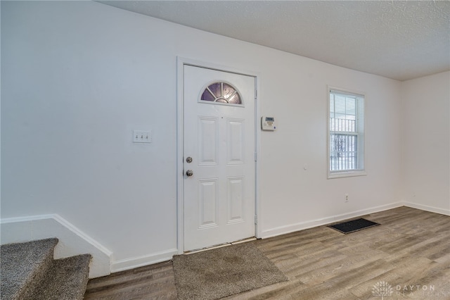 foyer with wood-type flooring and a textured ceiling