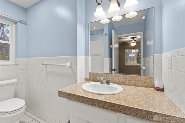 bathroom with tile patterned floors, ceiling fan, tile walls, and toilet