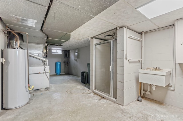 basement with a paneled ceiling and gas water heater