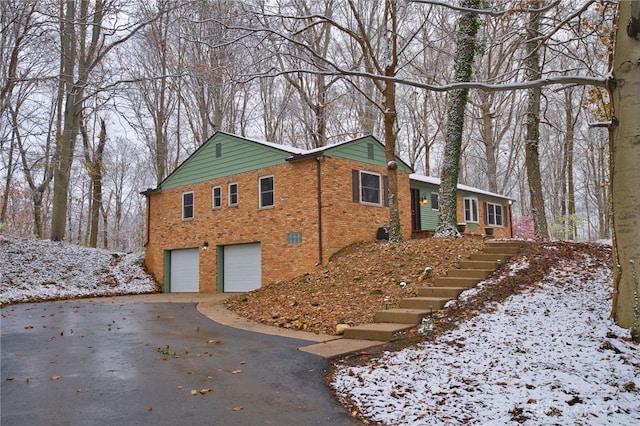 view of snowy exterior with a garage