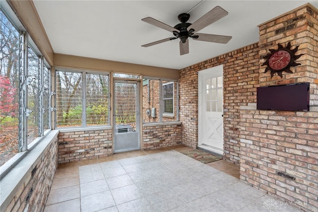 unfurnished sunroom with ceiling fan