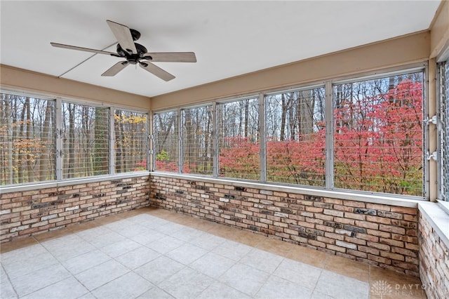 unfurnished sunroom featuring ceiling fan and a healthy amount of sunlight