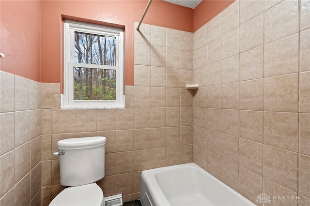 bathroom with tiled shower / bath combo and toilet