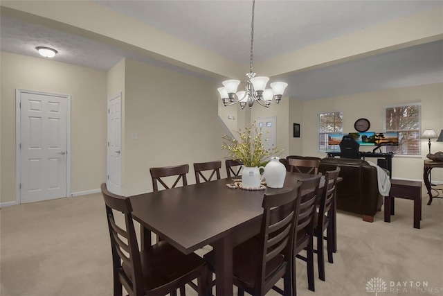 dining area featuring a notable chandelier and light colored carpet