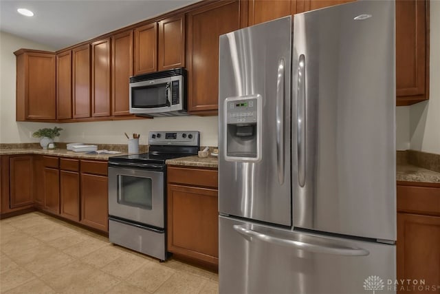 kitchen with light stone countertops and appliances with stainless steel finishes