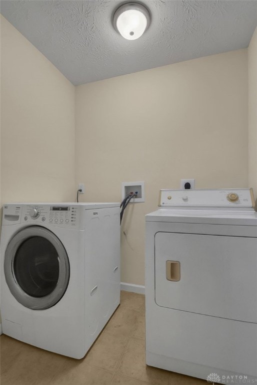 laundry area with washer and clothes dryer and a textured ceiling