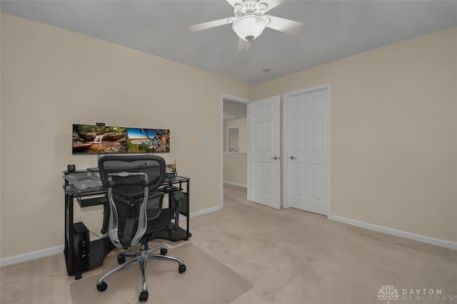 home office featuring light carpet and ceiling fan