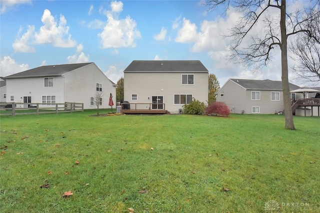 back of property featuring a yard and a wooden deck