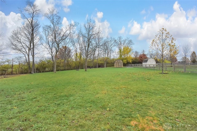 view of yard with a rural view and a shed