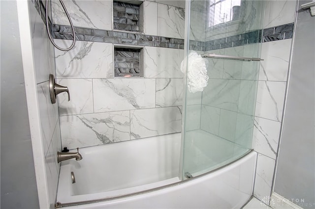 bathroom featuring combined bath / shower with glass door