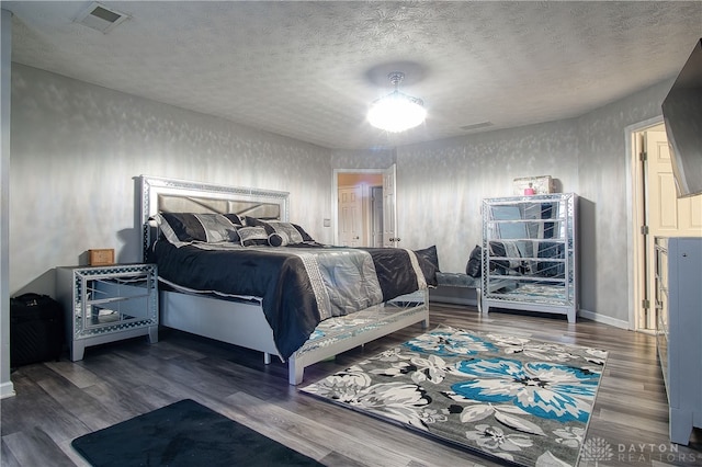 bedroom with wood-type flooring and a textured ceiling