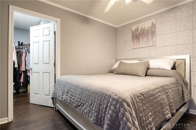 bedroom featuring dark wood-type flooring, ceiling fan, ornamental molding, tile walls, and a closet