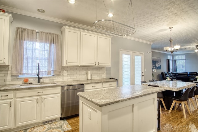 kitchen featuring dishwasher, white cabinetry, a kitchen island, and sink