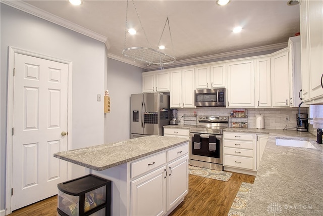 kitchen featuring white cabinetry, dark wood-type flooring, crown molding, a kitchen island, and appliances with stainless steel finishes