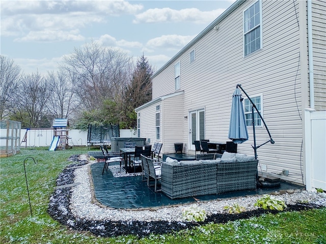 exterior space featuring a lawn, an outdoor living space, a trampoline, a playground, and a patio