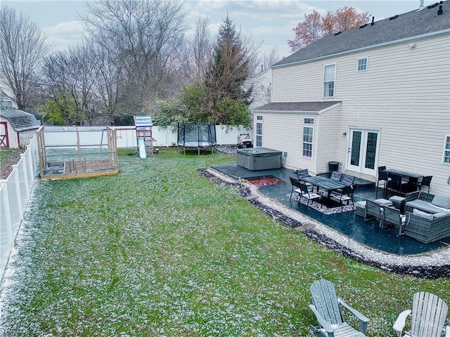 view of yard with an outbuilding, a patio, a trampoline, and a hot tub