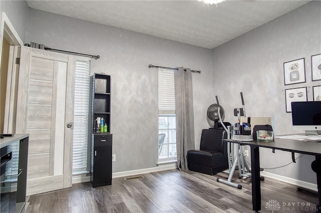 office area with hardwood / wood-style floors and a textured ceiling