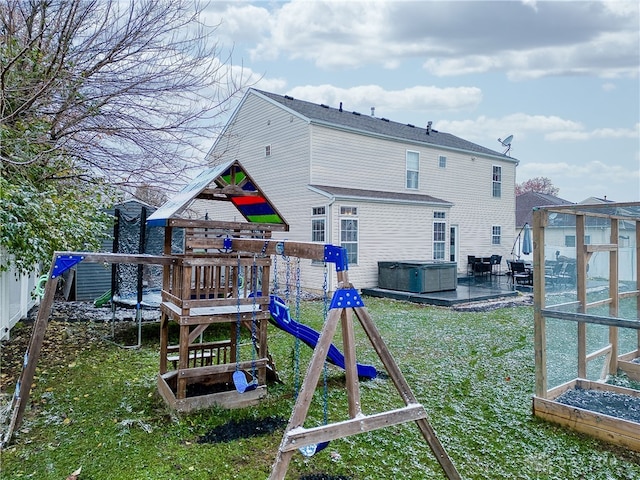 back of property with a lawn, an outbuilding, and a playground