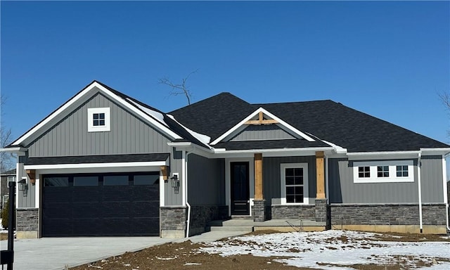 craftsman house with a porch, a garage, a shingled roof, stone siding, and concrete driveway