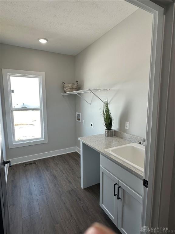 clothes washing area with hookup for a washing machine, visible vents, a sink, electric dryer hookup, and laundry area