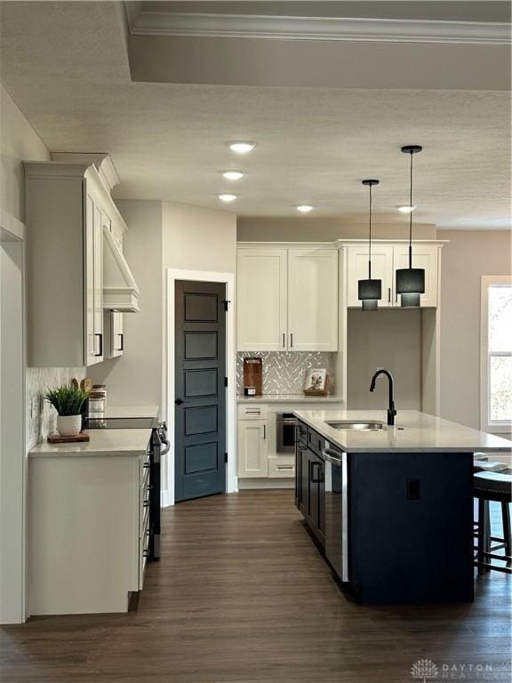 kitchen with hanging light fixtures, white cabinetry, light countertops, and a sink