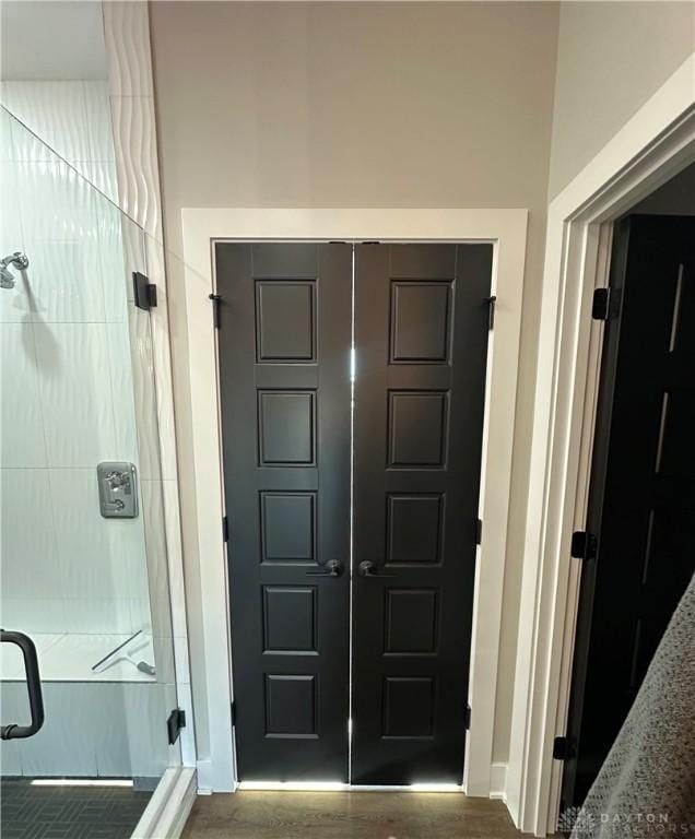 interior space featuring a stall shower and wood finished floors