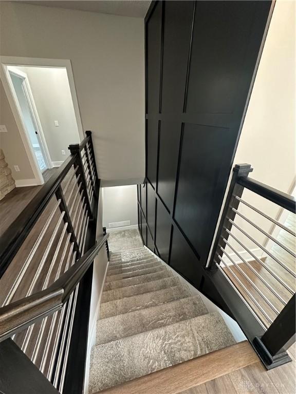 stairway with baseboards and wood finished floors