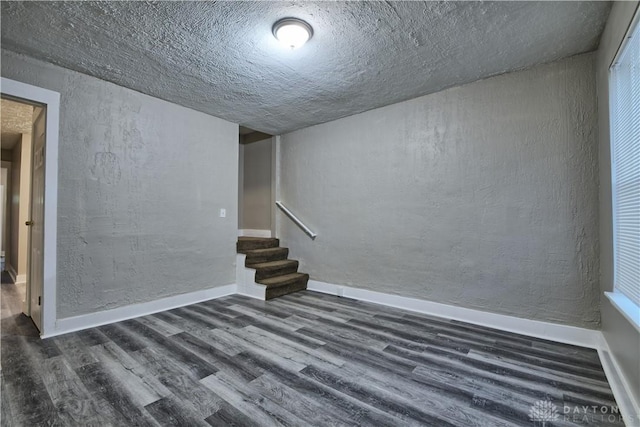 basement with dark hardwood / wood-style floors and a textured ceiling