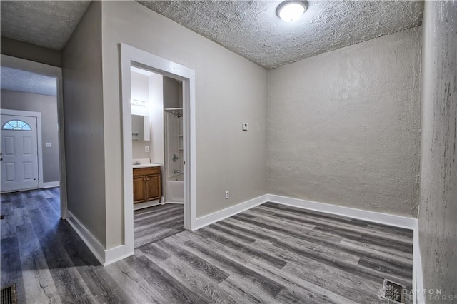 unfurnished room with dark hardwood / wood-style floors and a textured ceiling