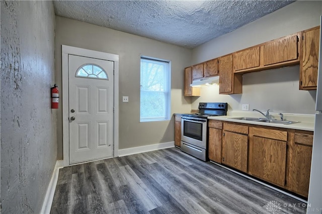 kitchen featuring stainless steel electric stove, dark hardwood / wood-style flooring, sink, and a textured ceiling