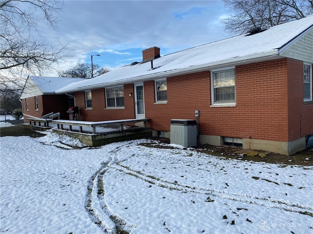 snow covered property with central AC unit