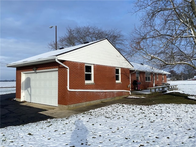 view of snowy exterior with a garage